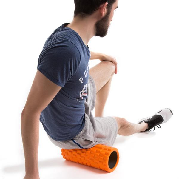 A man foam rolling his glutes with a trigger point foam roller